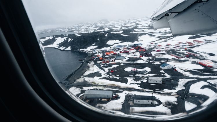 Landing approach to King George Island, South Shetland Islands: First view of the village of Villa las Estrellas with the research station.