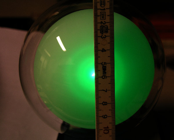Foto eines gebeugten Elektonenstrahls auf einem Fluoreszenzschirm mit Maßstab.