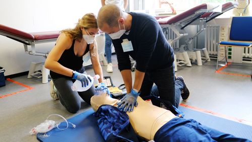 Two students are practicing resuscitation on a manikin.