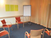Foto C3L Hochschulambulanzen - Räumlichkeiten - Seminarraum mit Sitzgruppe und Flipchart